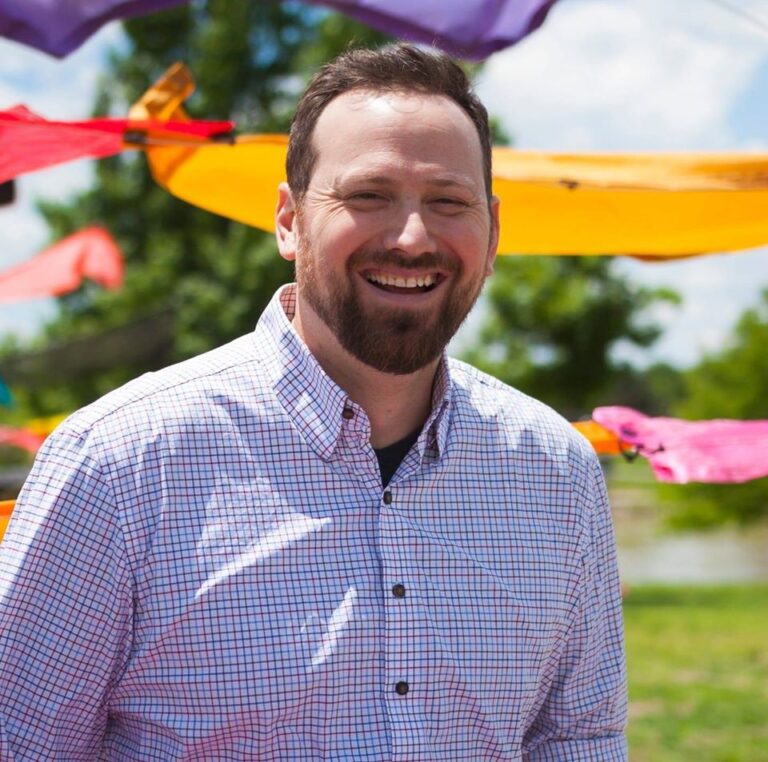 Ryan W. Gates smiling in front of the Rachel B. Hayes structure from Harvester Arts