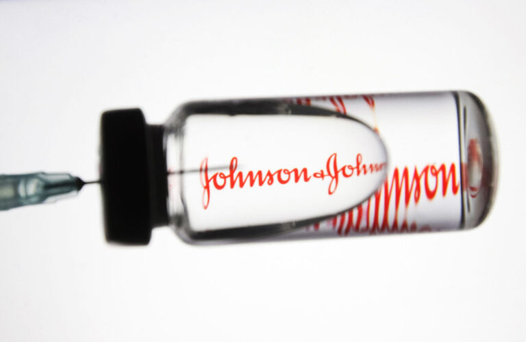 S syringe extracts fluid from a Johnson & Johnson COVID-19 vaccine bottle