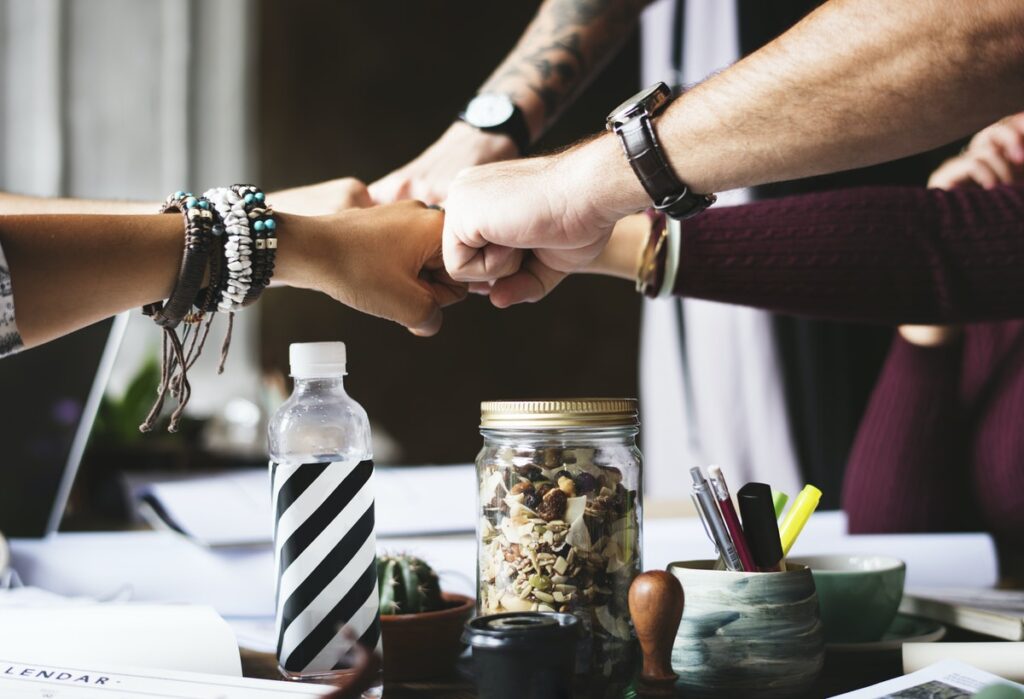 Fist-bumping hands in celebration of conducting a win-win scenario in marketing