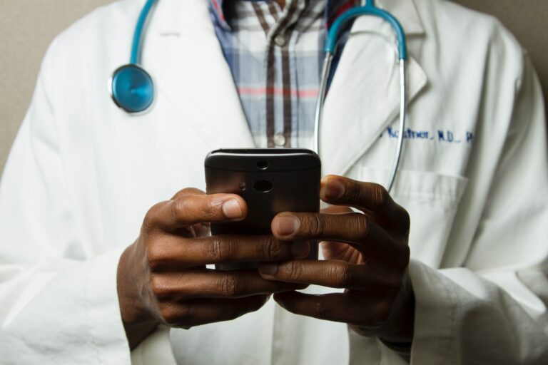 A doctor at an FQHC Federally Qualified Health Center using his phone for digital marketing