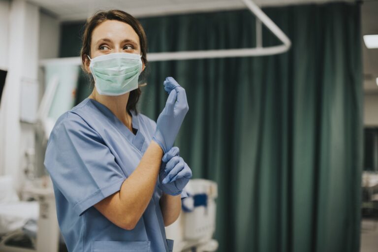 A nurse putting on a glove at a health organization funded with ARPA grant funds